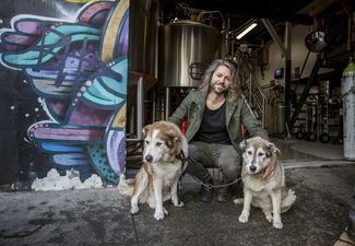 Jos crouching next to his two dogs.