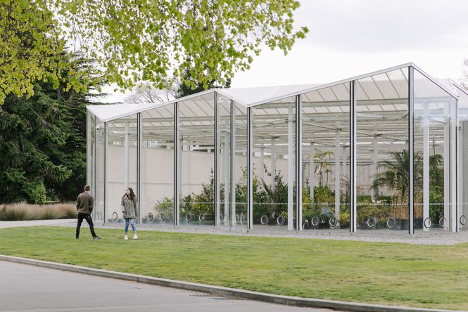 Two people standing outside the glasshouse at the Botanic Gardens.